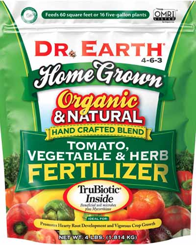 یک تصویر مربع نزدیک از بسته بندی کود گوجه فرنگی، سبزیجات و گیاهان دارویی دکتر زمین جدا شده در پس زمینه سفید.